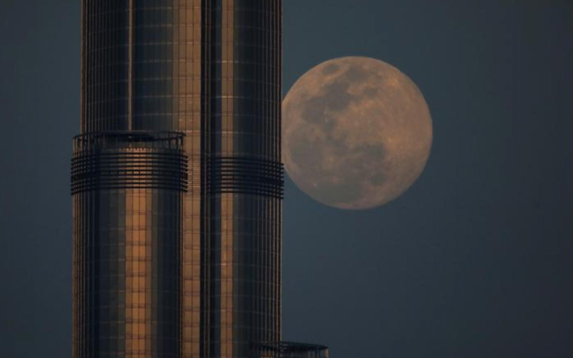 يظهر القمر العملاق خلف برج خليفة، أطول برج في العالم، في مدينة دبي